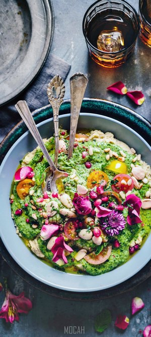 Green pesto dip with tomatoes, herbs, and flowers