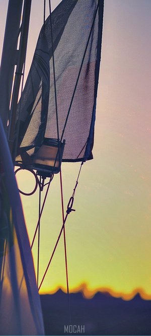 Sailboat rigging against a sunset sky