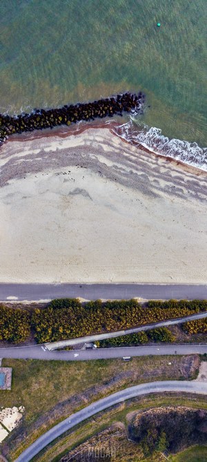 Aerial view of a beach and coastline with a buoy