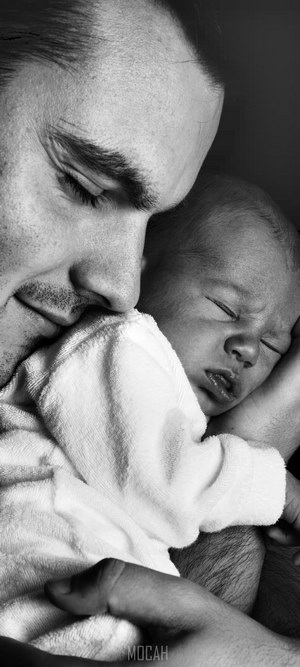 Father Cuddling Newborn Baby