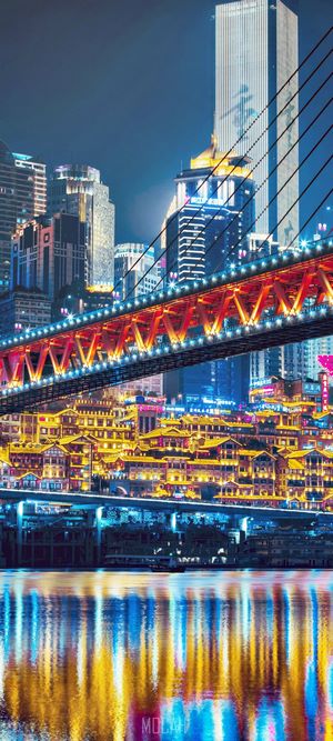 Cityscape at night with illuminated bridge and reflections