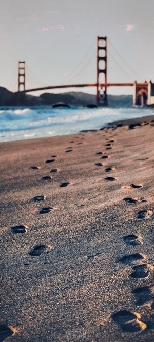 Footprints on beach with Golden Gate Bridge