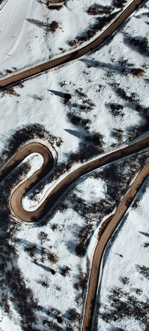 Aerial view of a winding road through a snowy landscape