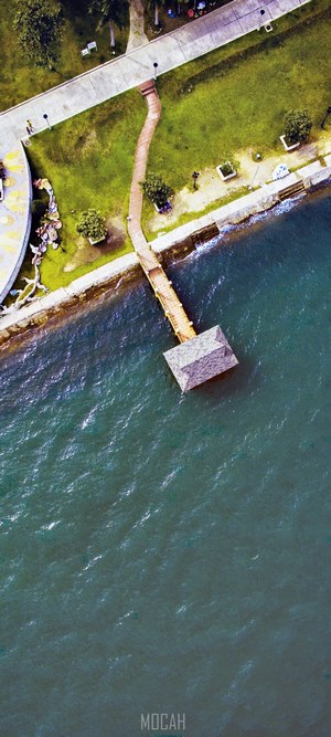 Aerial view of a wooden jetty with a small structure over the sea