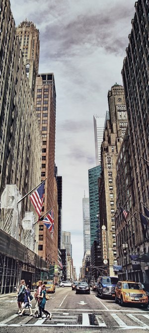 People crossing street in New York with skyscrapers