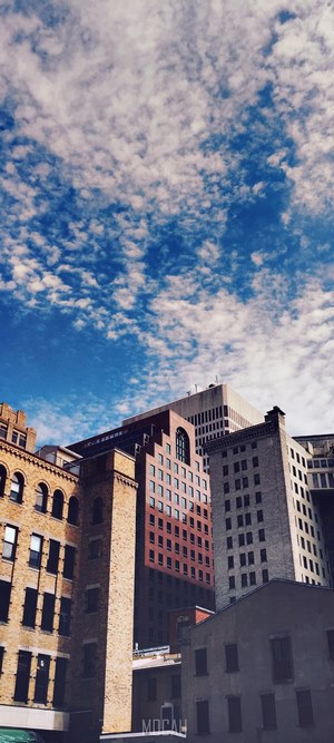 City buildings against a cloudy blue sky