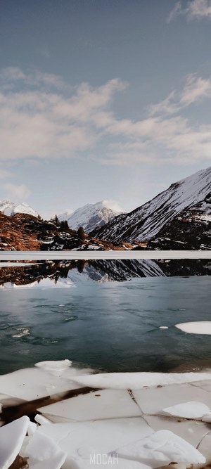 Snowy mountains reflected in a frozen lake