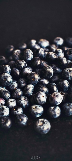 Pile of blueberries on a dark surface
