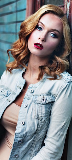 Woman with blonde hair and red lipstick wearing a denim jacket