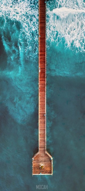 Wooden pier over turquoise ocean waves