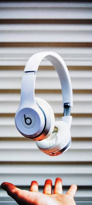 White Beats Solo Headphones Floating Above Hand