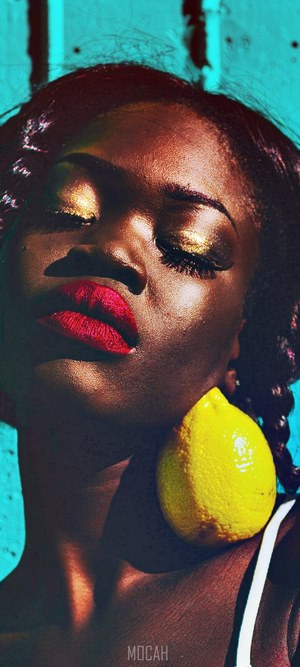 Woman with red lipstick and gold eyeshadow holding a lemon