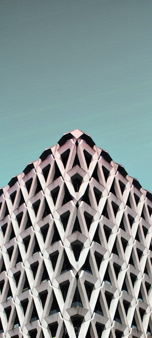 Geometric building facade against a teal sky