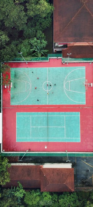 Aerial view of basketball and tennis courts with people playing