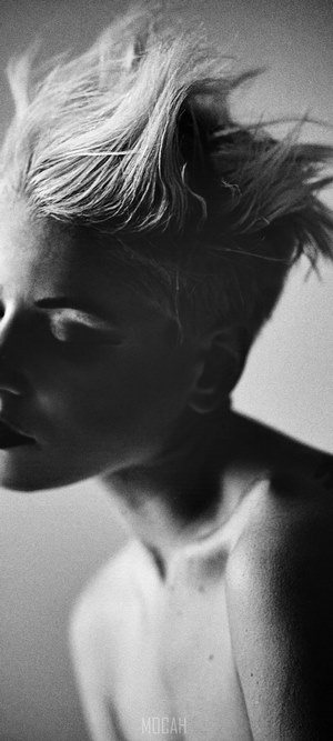Black and white shot of a shirtless woman with short spiked blonde hair