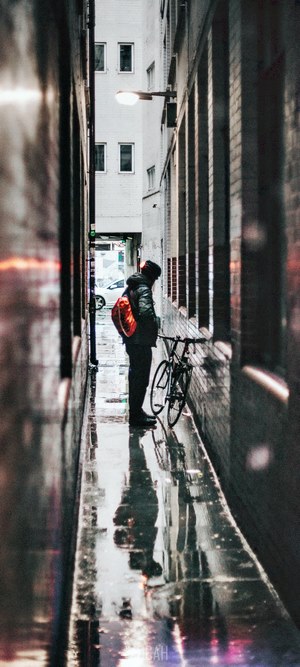 Person with bicycle in alleyway