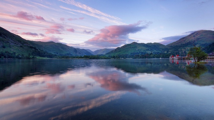 Lake and mountains at sunrise with pink clouds