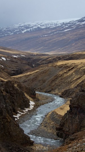river flowing through a rocky valley with the mountains in the ...