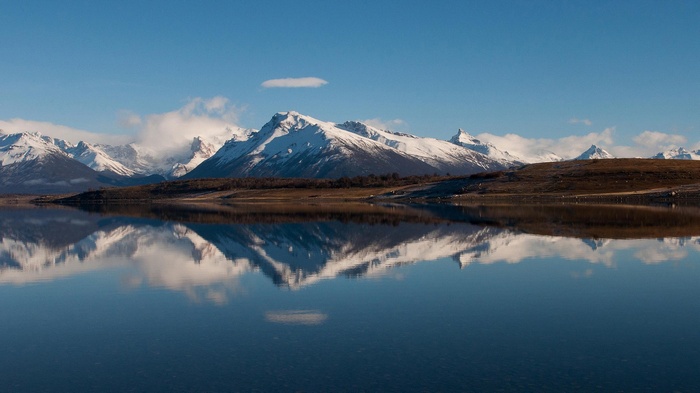 Snow-capped mountains reflected in a calm lake