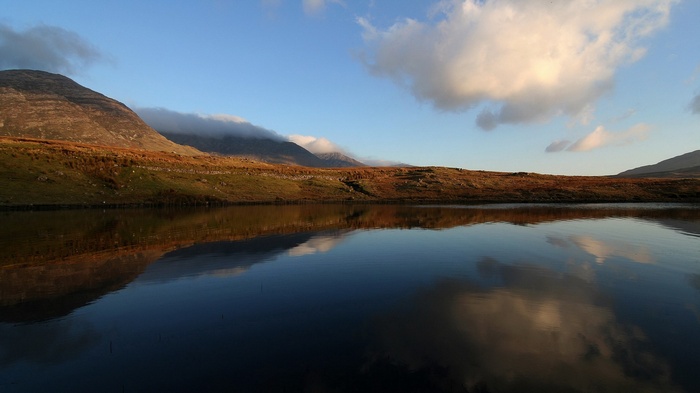 Mountain landscape reflected in a calm lake at sunset