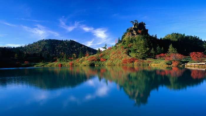 Autumn mountain lake with colorful foliage and reflection