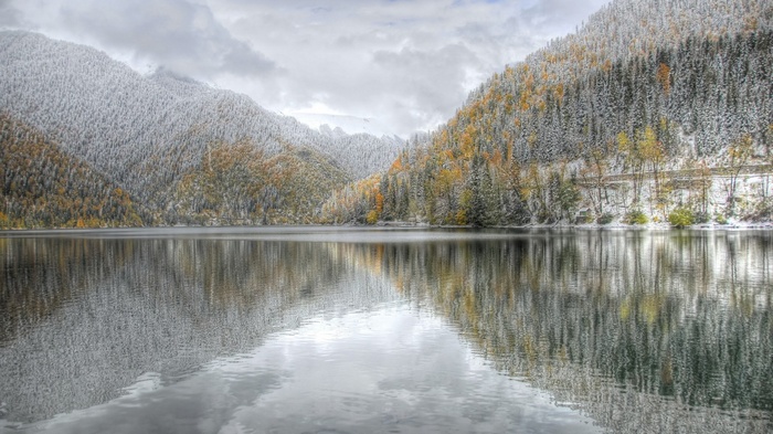 Snow-dusted mountains reflected in a calm lake