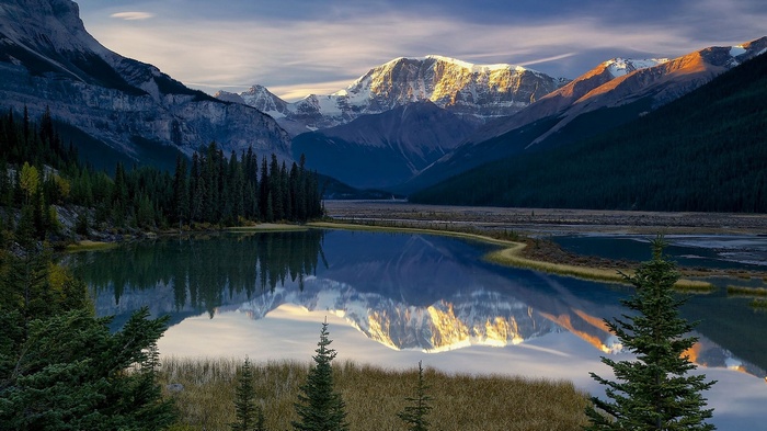Mountain range reflected in a calm lake at sunset