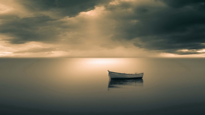A lone rowboat on a calm sea under a cloudy sky