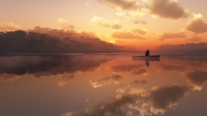 Man in a boat on a lake at sunset