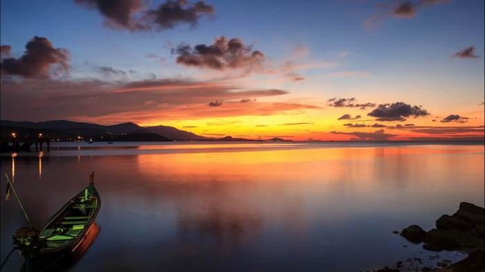 Boat on calm water during sunset