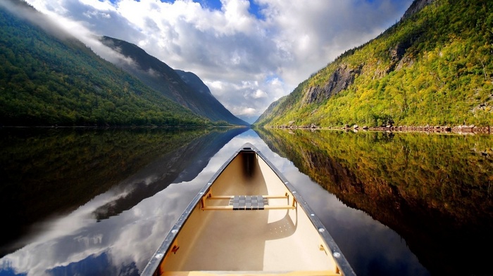 Canoe on a calm lake between mountains