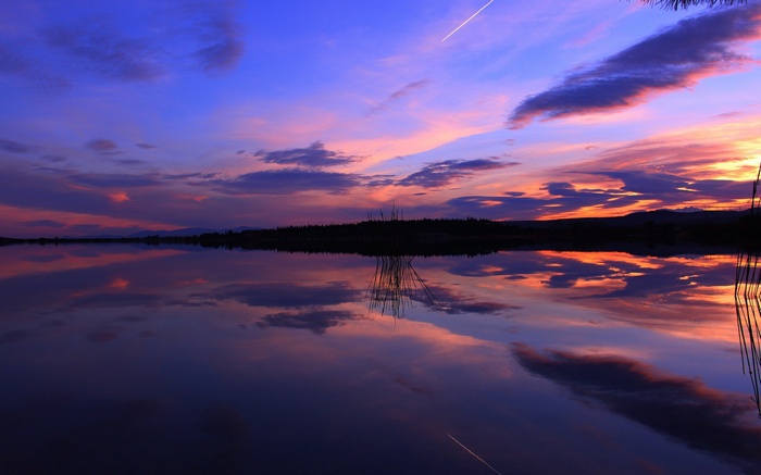 Sunset over a calm lake with colorful clouds and reflections