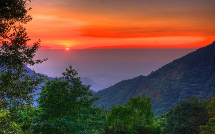 Sunset over forested mountains