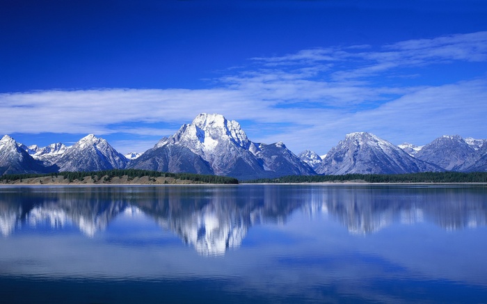 Snow-capped mountains reflected in a calm lake