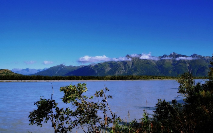 River and Mountains under a Blue Sky