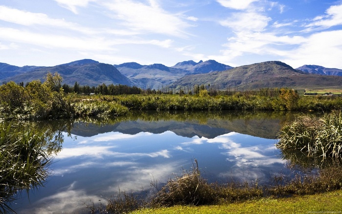 Mountains reflected in a calm lake with vegetation
