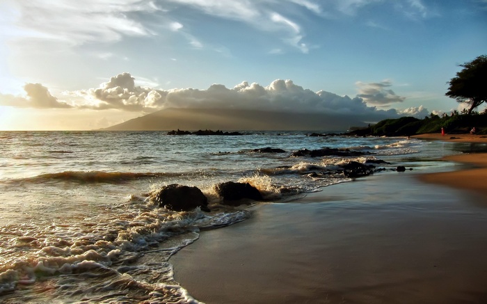 Waves crashing on a rocky beach at sunset