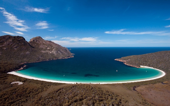 Bay with white sand beach and forested hills