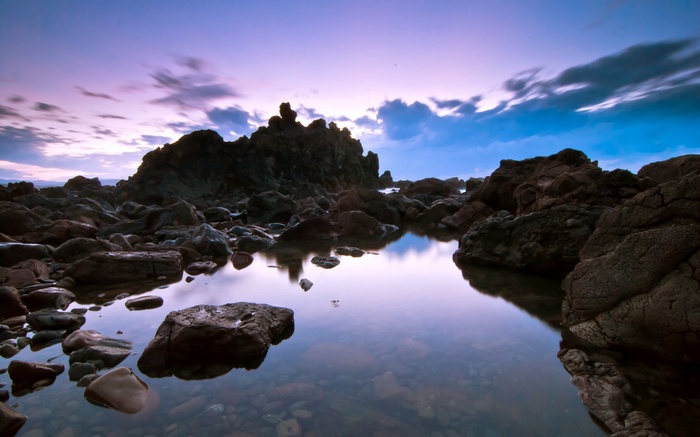Rocky coastline with tide pools at sunset