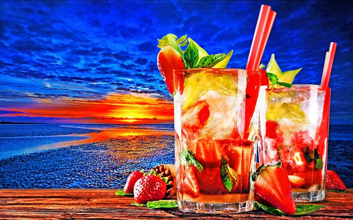 Two tropical cocktails on a wooden table at sunset