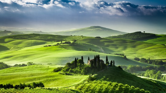 Tuscan landscape with rolling green hills and a villa