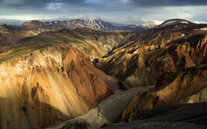 Mountainous landscape with colorful eroded hills and a riverbed