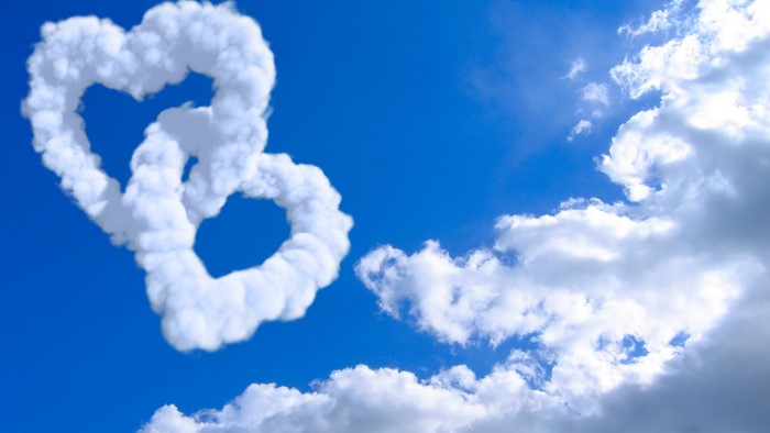 Two heart-shaped clouds in a blue sky