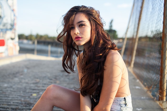 Woman with long brown hair sitting outdoors