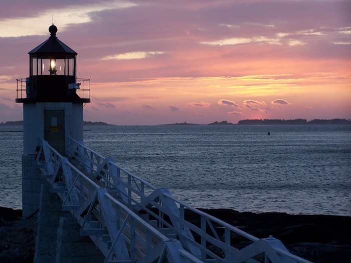 Lighthouse at sunset over the ocean