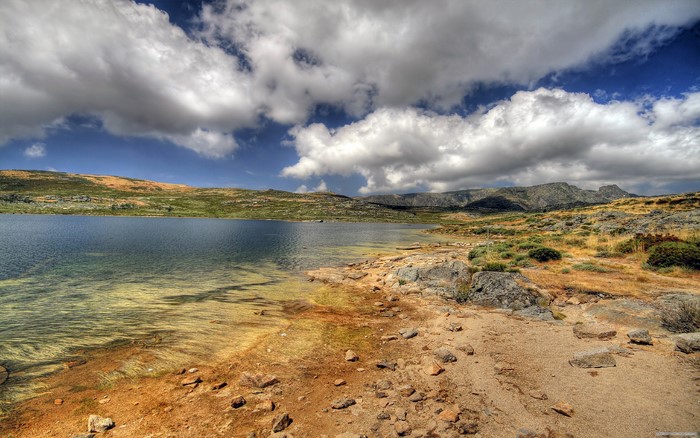 Lake and mountains under a cloudy sky