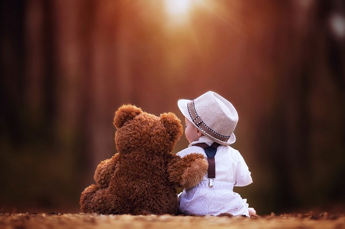 Child Sitting with Teddy Bear in Warm Sunset Light