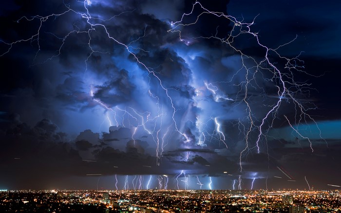 Lightning storm over a city at night