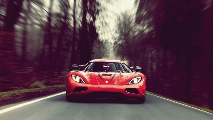 Red Koenigsegg Agera driving on a forest road