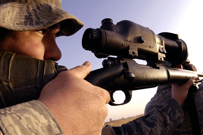 Soldier aiming a sniper rifle with scope